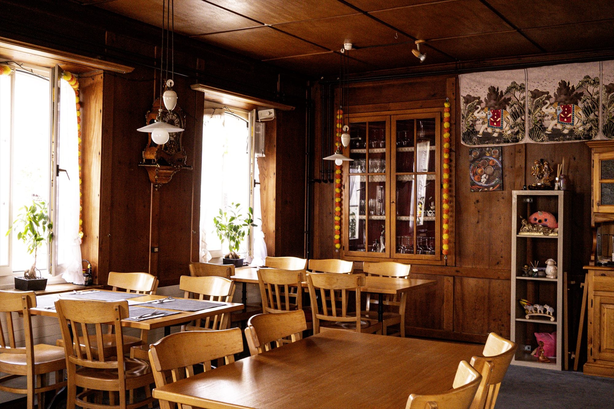 Gastraum mit Holzdecke, Vitrine und indischer Dekoration
