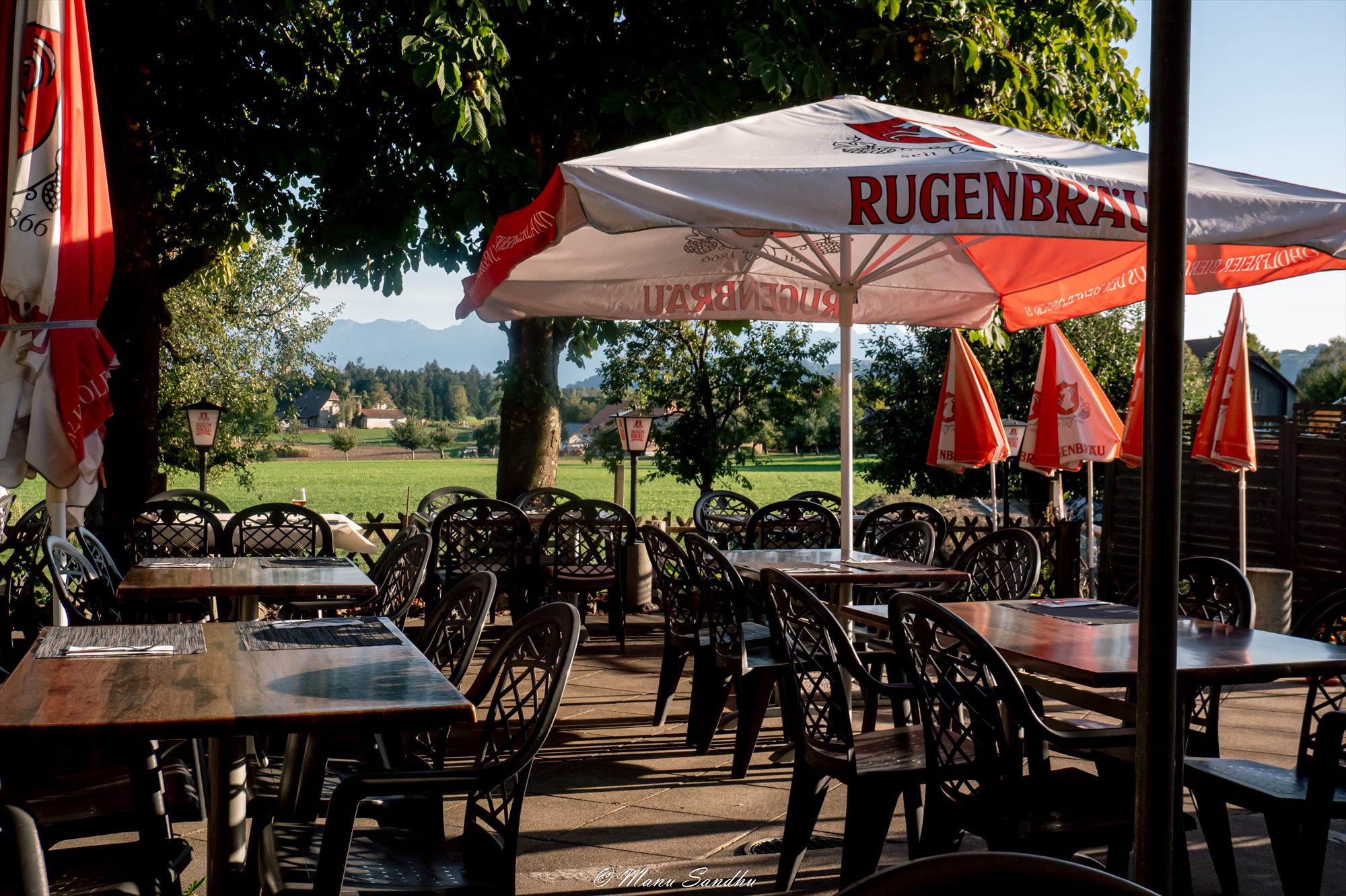 Gartenterrasse mit Sonnenschirmen und Bergblick