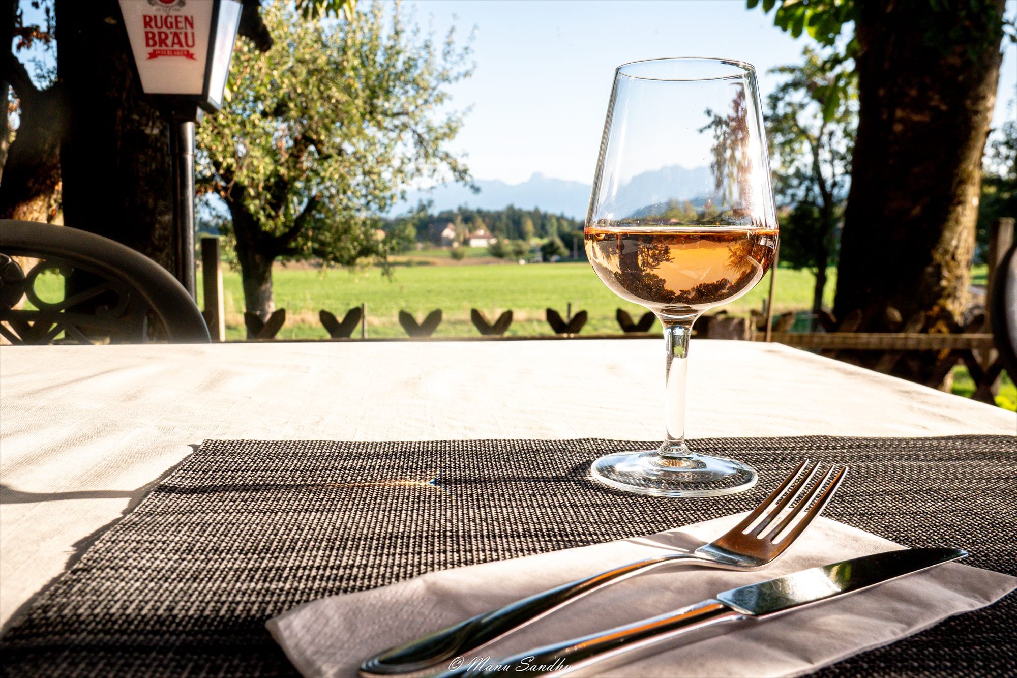 Glas Wein auf dem Terrassentisch mit Blick auf die Berge