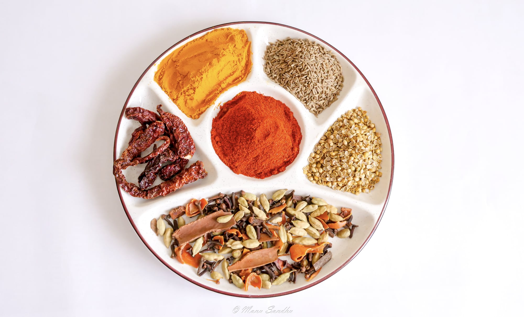 Gewürzteller mit Kurkuma, Kreuzkümmel, Chili, Koriander und Gewürzmischung